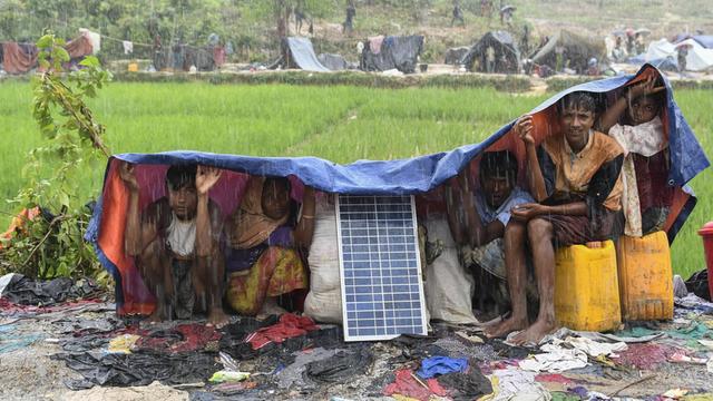 Angehörige der Rohingya schützen sich in einem Flüchtlingslager in Bangladesch vor Monsun-Regen.