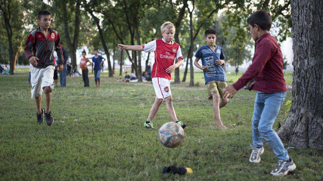 Kinder unterschiedlicher Herkunft spielen Fußball zusammen. Kinder unterschiedlicher Herkunft spielen Fußball zusammen.