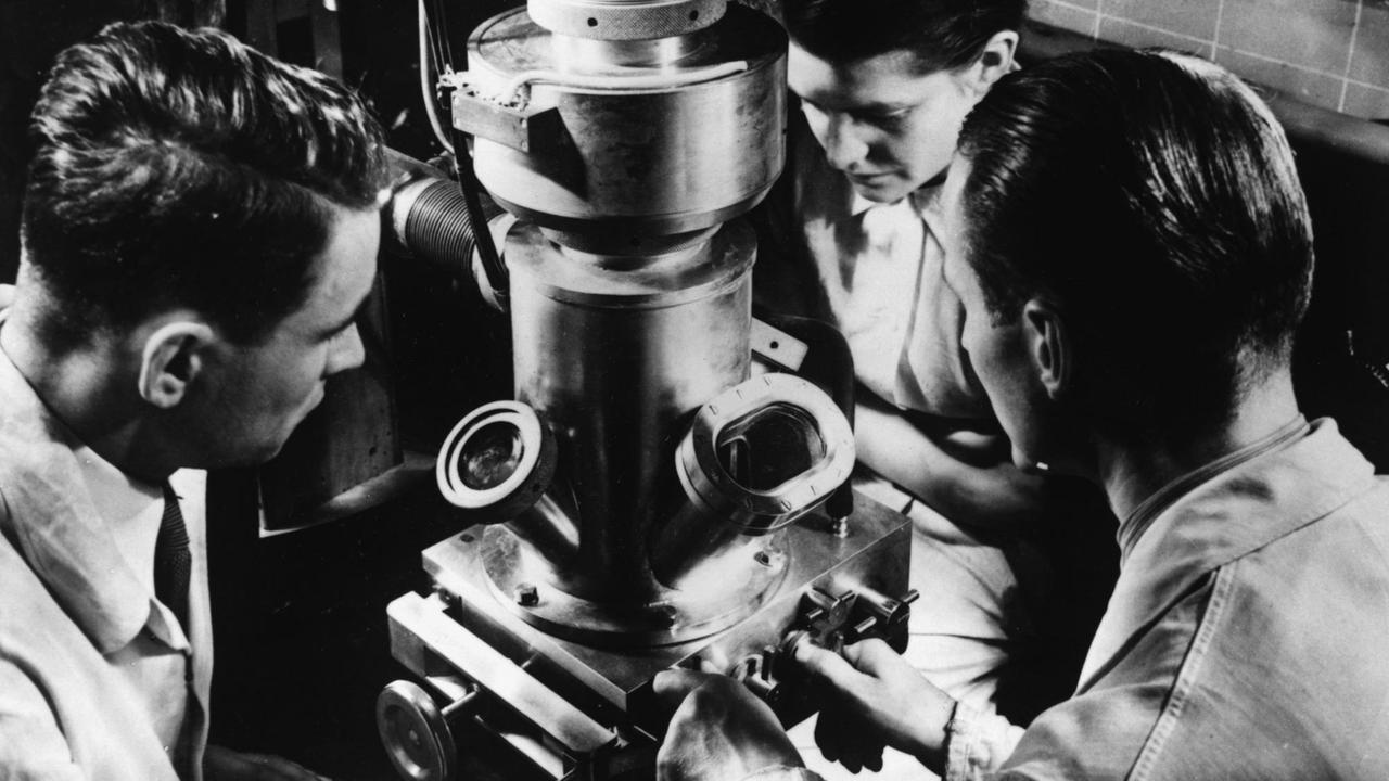 Eine Forscherin und ein Forschung sitzen um ein Elektronenmikroskop, um 1935/40 Eine Forscherin und ein Forschung sitzen um ein Elektronenmikroskop, um 1935/40