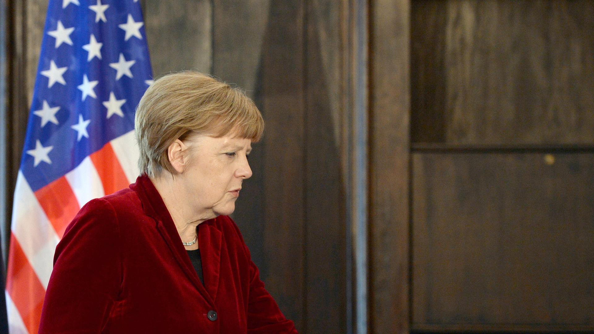 Angela Merkel geht an einer US-Flagge vorbei