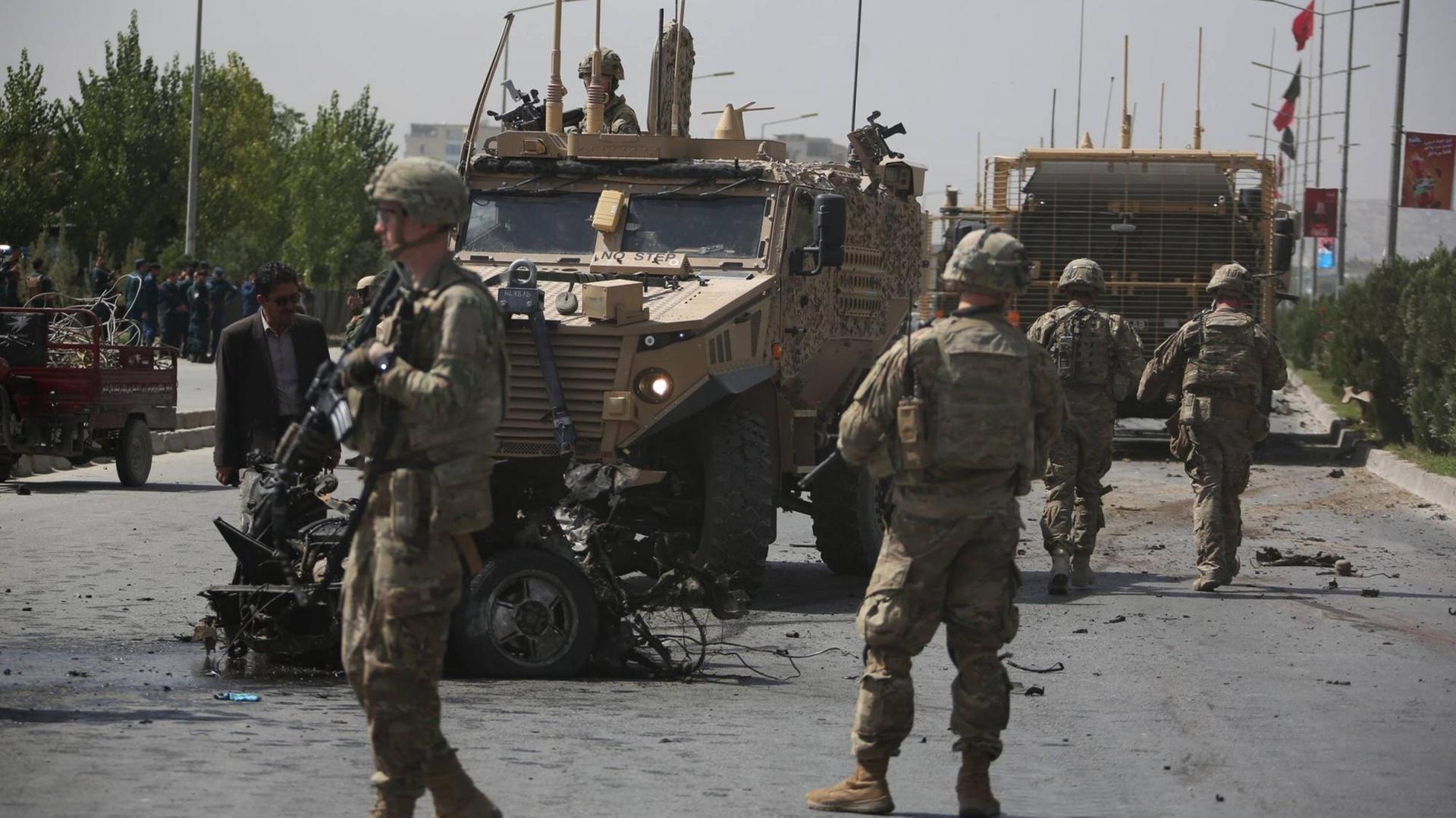 NATO-Soldaten untersuchen den Ort eines Selbstmordanschlags in Kabul, der einem NATO-Konvoi galt. NATO-Soldaten untersuchen den Ort eines Selbstmordanschlags in Kabul, der einem NATO-Konvoi galt.