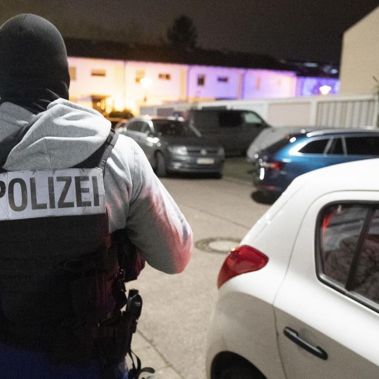 20.02.2020, Hessen, Hanau: Ein Polizeibeamter steht nach der tödlichen Schießerei in der Nähe eines der Tatorte auf der Straße. Nach den tödlichen Schüssen auf neun Menschen in Hanau ist der mutmaßliche Täter tot in einer Wohnung aufgefunden worden. Foto: Boris Roessler/dpa | Verwendung weltweit