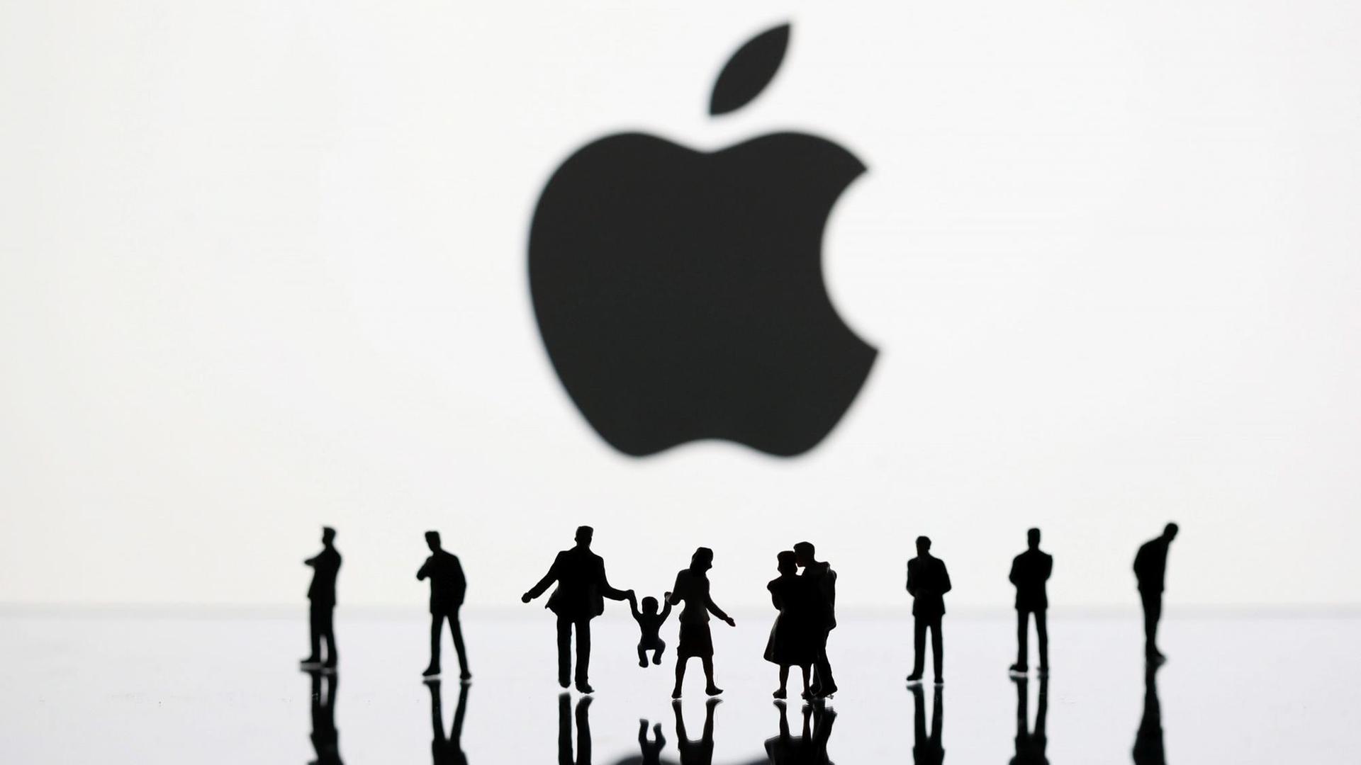 Menschen unter einem sehr großen Apple-Logo Menschen unter einem sehr großen Apple-Logo