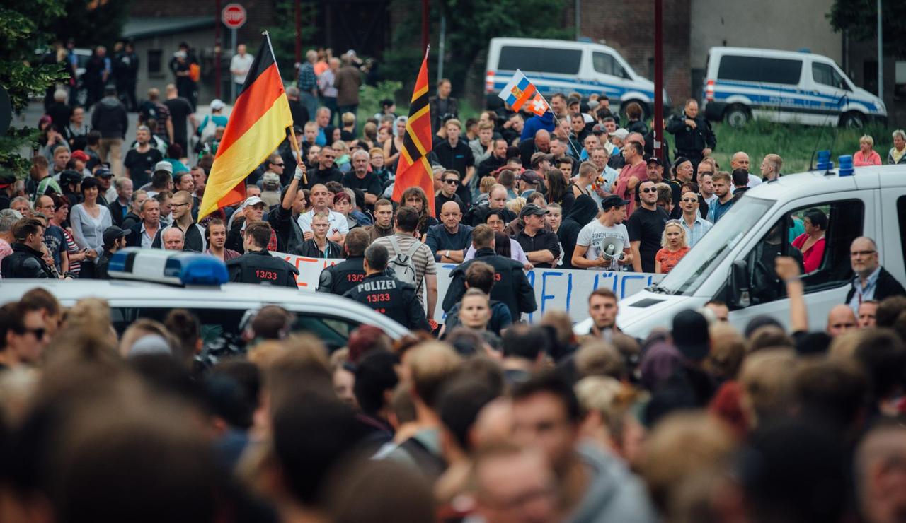 Gegner der Flüchtlingsunterkunft stehen am 26.06.2015 in Freital (Sachsen) in der Nähe des ehemaligen Leonardo-Hotels, das jetzt als Flüchtlingsheim dient. Gegner der Flüchtlingsunterkunft stehen am 26.06.2015 in Freital (Sachsen) in der Nähe des ehemaligen Leonardo-Hotels, das jetzt als Flüchtlingsheim dient.