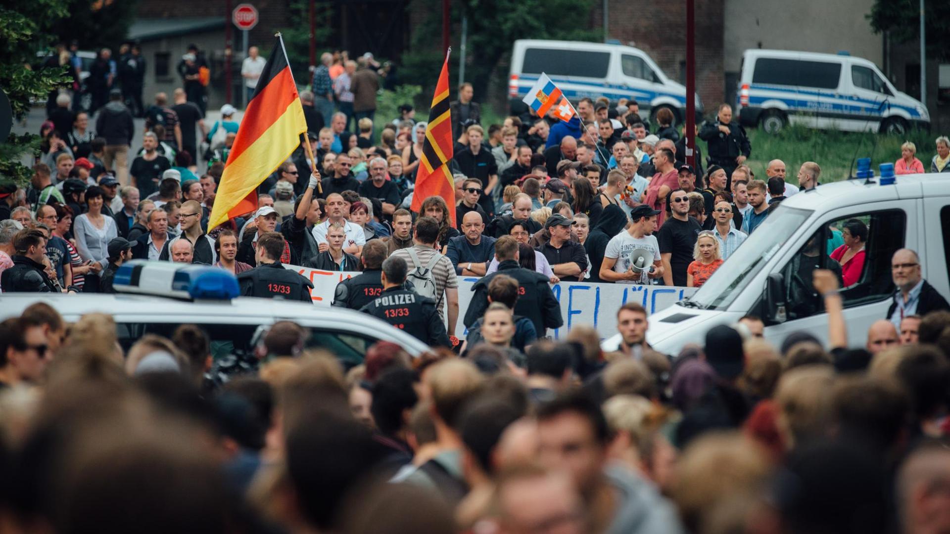 Gegner der Flüchtlingsunterkunft stehen am 26.06.2015 in Freital (Sachsen) in der Nähe des ehemaligen Leonardo-Hotels, das jetzt als Flüchtlingsheim dient. Gegner der Flüchtlingsunterkunft stehen am 26.06.2015 in Freital (Sachsen) in der Nähe des ehemaligen Leonardo-Hotels, das jetzt als Flüchtlingsheim dient.