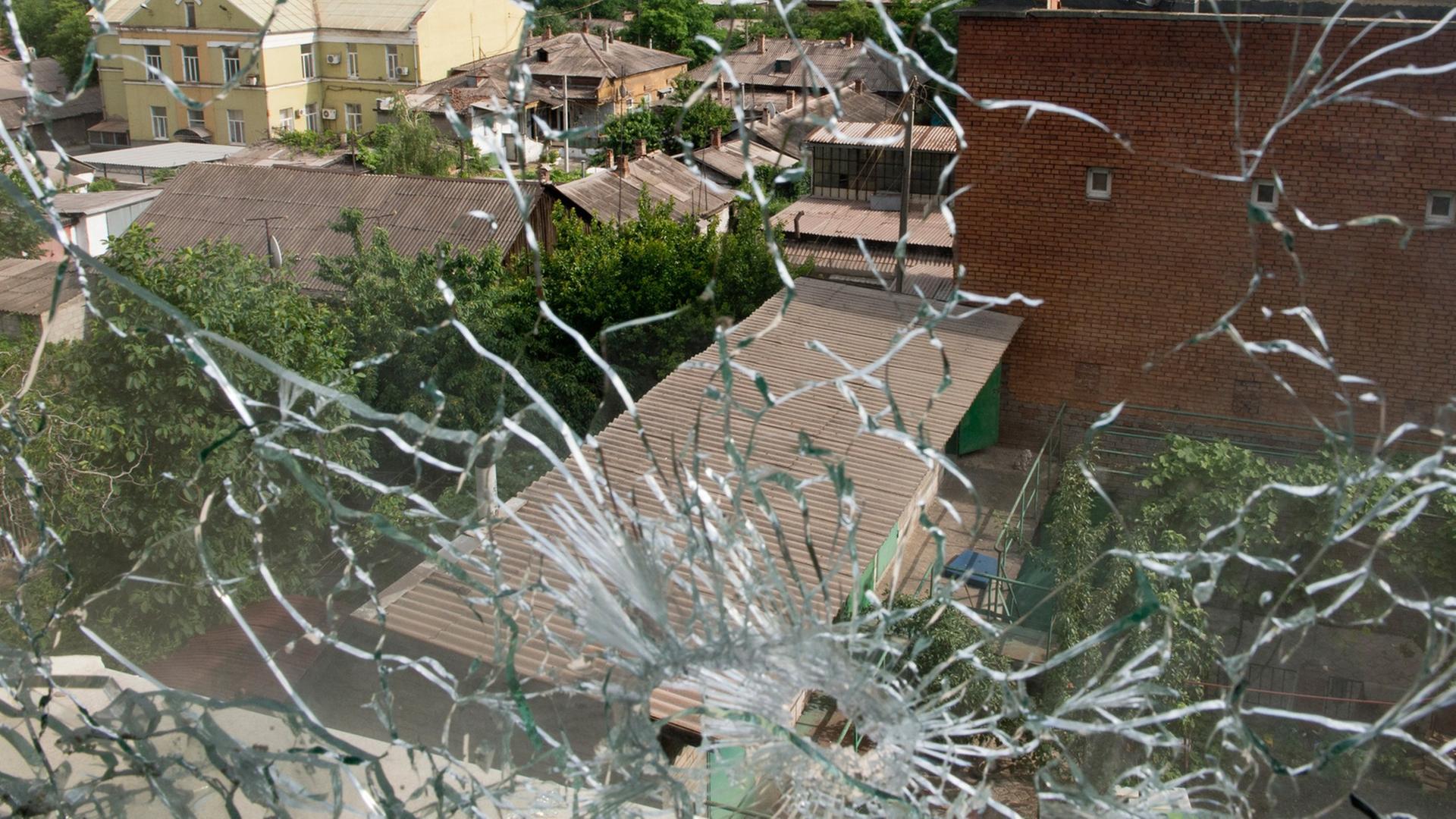 Blick aus einem von Kugeln zerstörten Fenster in der ostukrainischen Stadt Mariupol am Asowschen Meer Blick aus einem von Kugeln zerstörten Fenster in der ostukrainischen Stadt Mariupol am Asowschen Meer