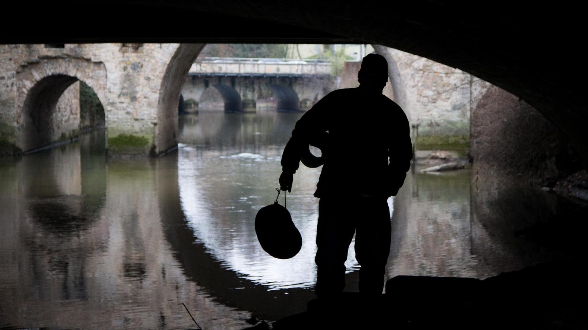 Ein Obdachloser als Silhouette am 25.01.2017 unter einer Brücke in Osnabrück (Niedersachsen). Ein Obdachloser als Silhouette am 25.01.2017 unter einer Brücke in Osnabrück (Niedersachsen).