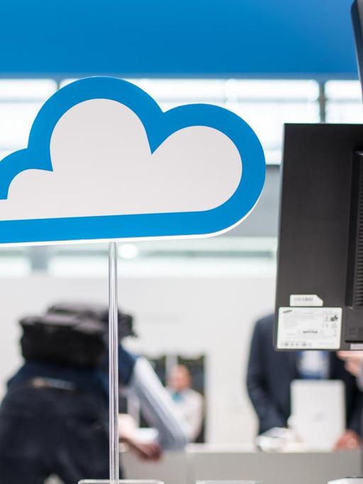 Eine Pappwolke auf einem Ständer als Symbol für Cloudcomputing steht neben Computermonitoren.