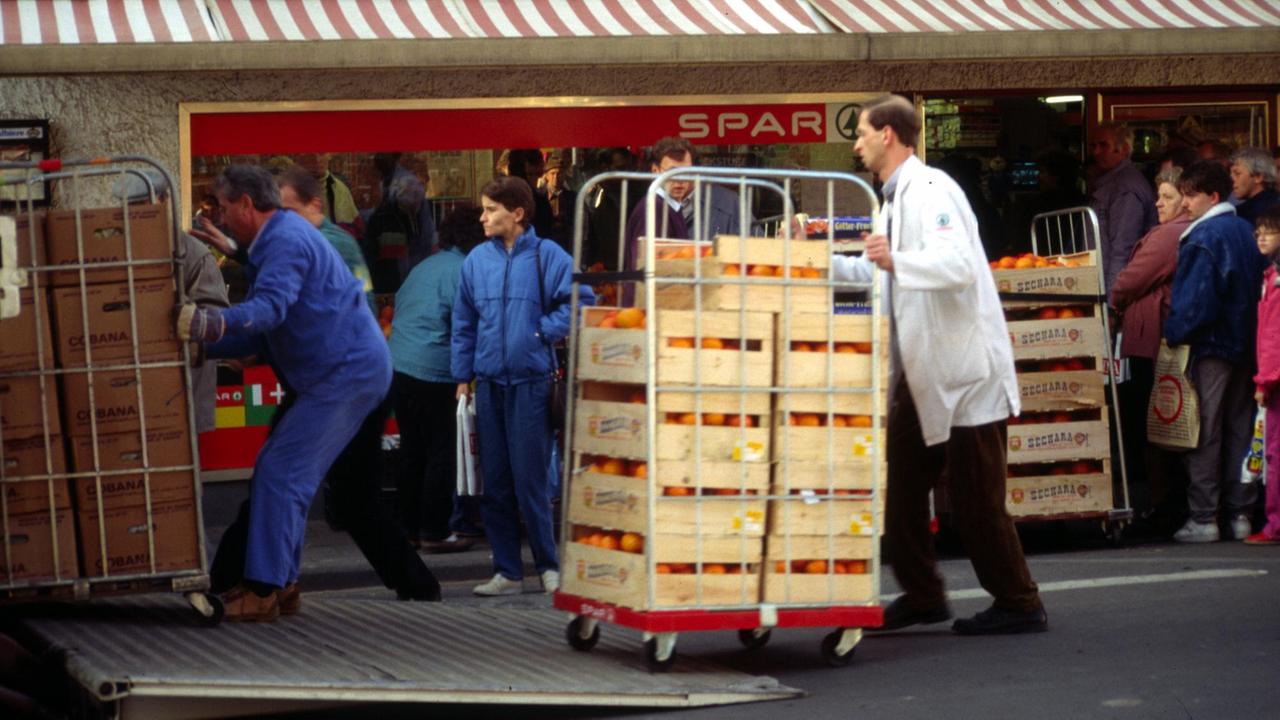 Vor einem Supermarkt werden zahlreiche Kisten angeliefert. Vor einem Supermarkt werden zahlreiche Kisten angeliefert.