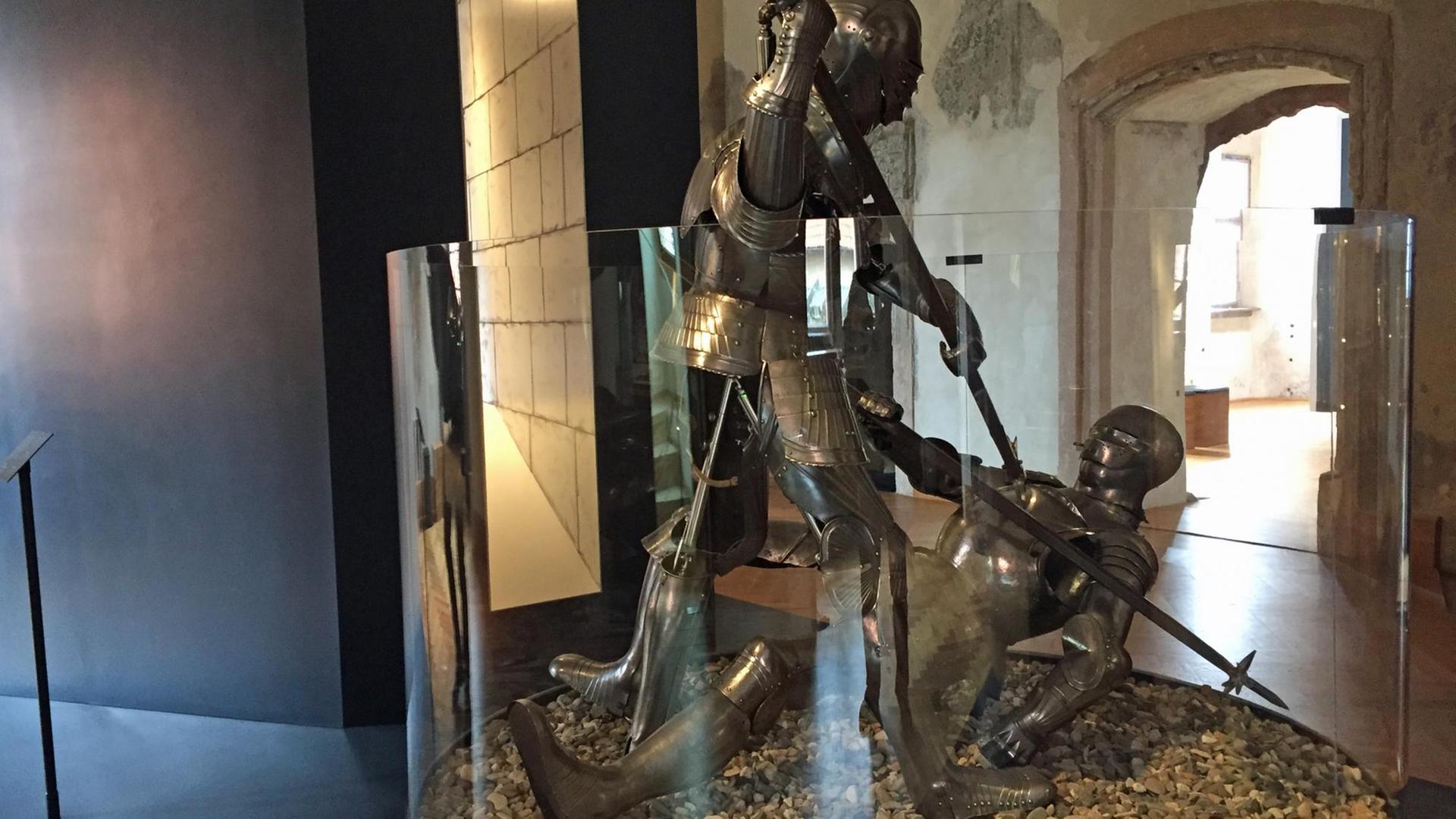 Zwei Ritterrüstungen sind im Deutschen Burgenmuseum hinter einer Vitrine in Kampfstellung angeordnet.