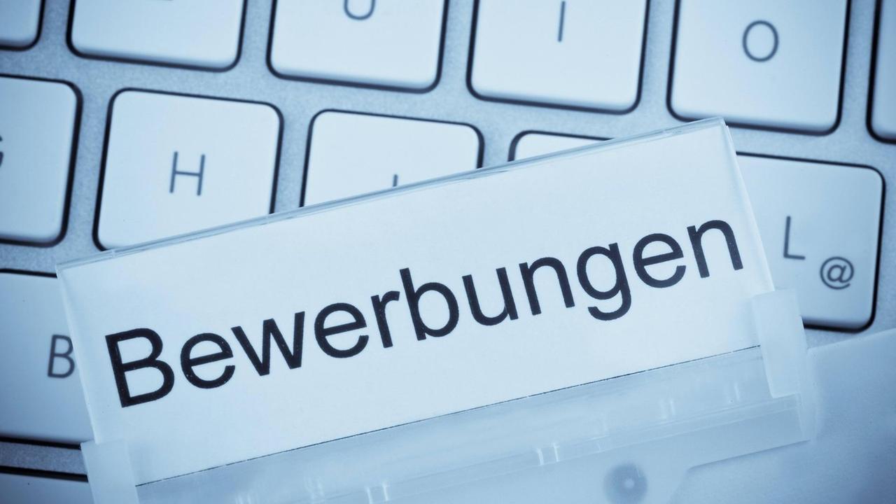Bewerbungsmappen auf einer Tastatur. Bewerbungsmappen auf einer Tastatur.