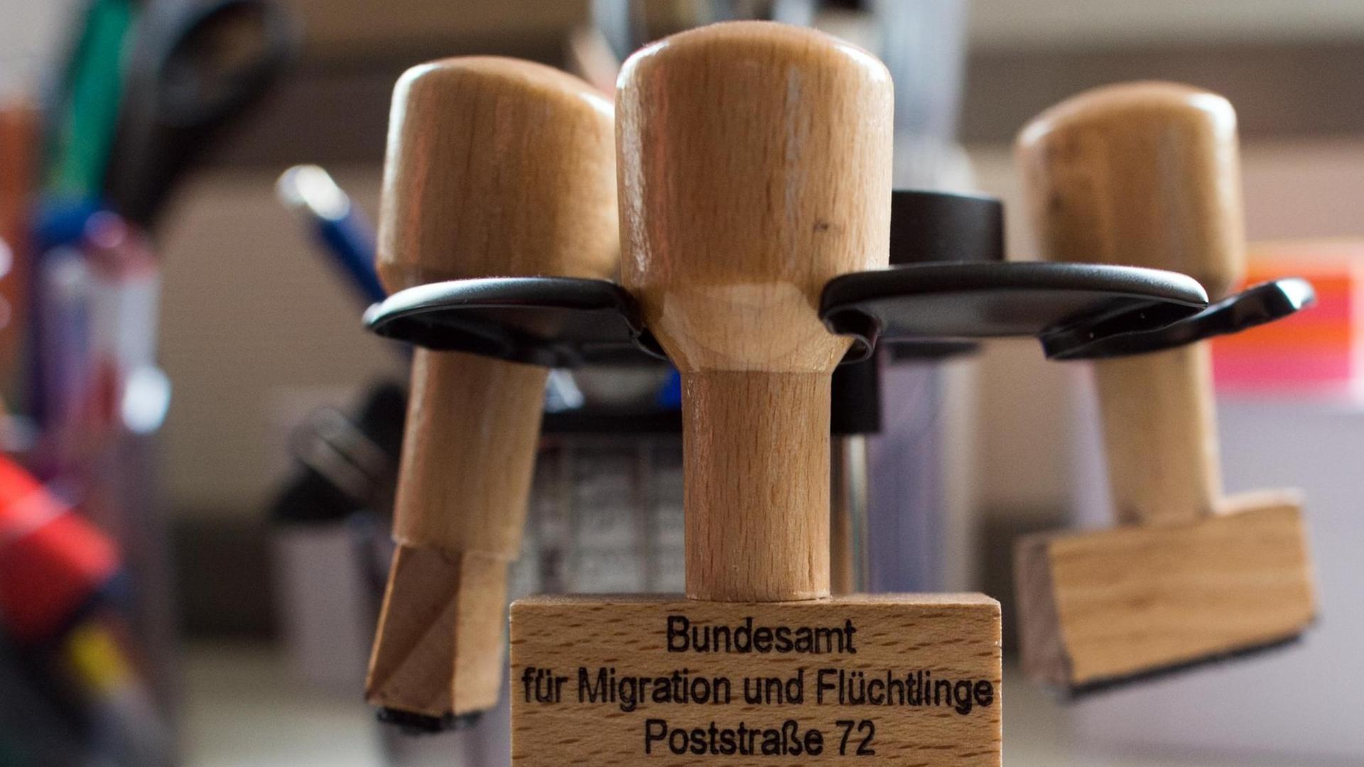 "Bundesamt für Migration und Flüchtlinge" steht in Eisenhüttenstadt (Brandenburg) in einem Büro des Ankunftszentrums des Bundesamtes für Migration und Flüchtlinge (BAMF) auf einem Stempel. Foto: Klaus-Dietmar Gabbert/dpa | Verwendung weltweit