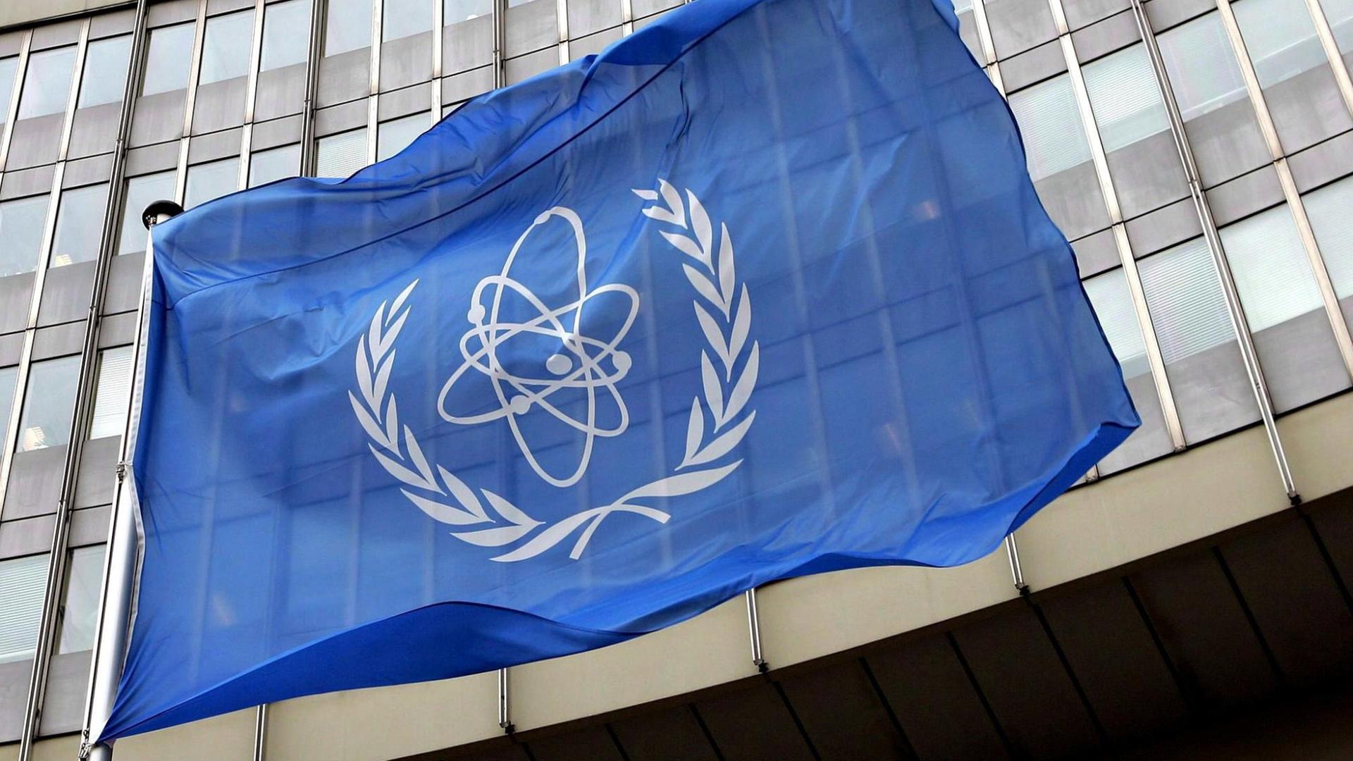 Vor dem Sitz der Internationalen Atomenergiebehörde in Wien weht eine blaue Flagge mit dem IAEA-Logo.