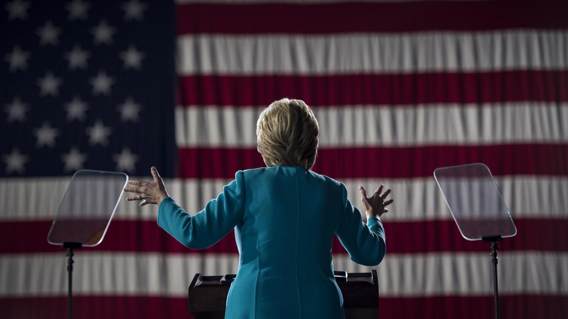Hillary Clinton vor der US-Flagge.