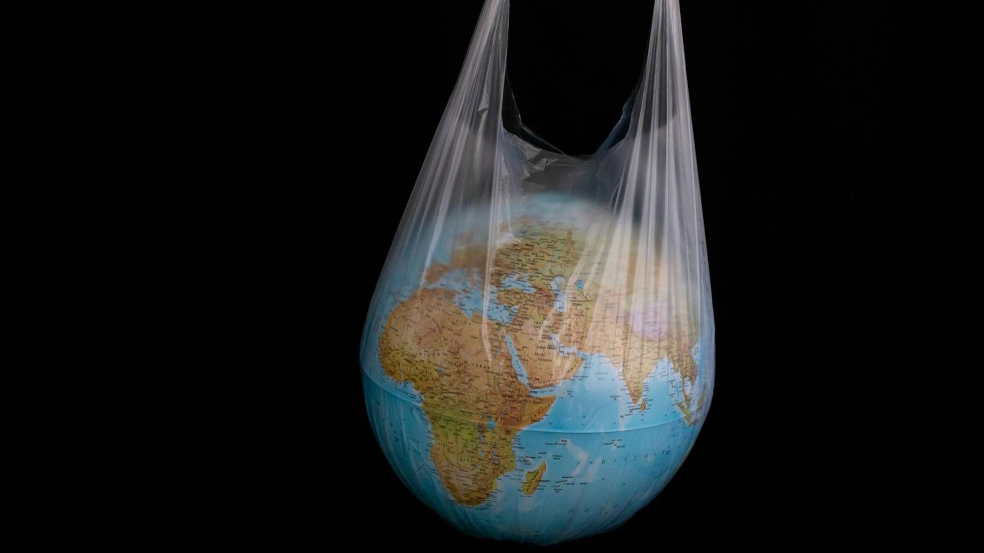 Ein Globus steckt in einer durchsichtigen Plastiktüte. Ein Globus steckt in einer durchsichtigen Plastiktüte.