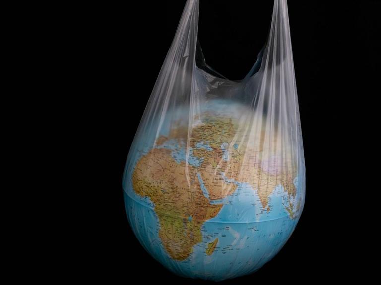 Ein Globus steckt in einer durchsichtigen Plastiktüte.