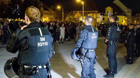 Bewaffnete Polizeibeamte stehen in Bautzen (Sachsen) auf dem Kornmarkt etwa 350 Versammlungsteilnehmern aus dem politisch rechten Spektrum gegenüber. Es ist dunkel.