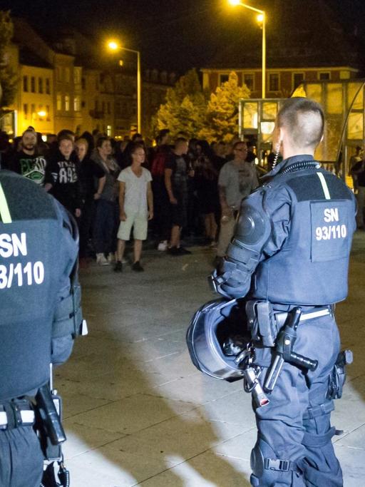 Bewaffnete Polizeibeamte stehen in Bautzen (Sachsen) auf dem Kornmarkt etwa 350 Versammlungsteilnehmern aus dem politisch rechten Spektrum gegenüber. Es ist dunkel.