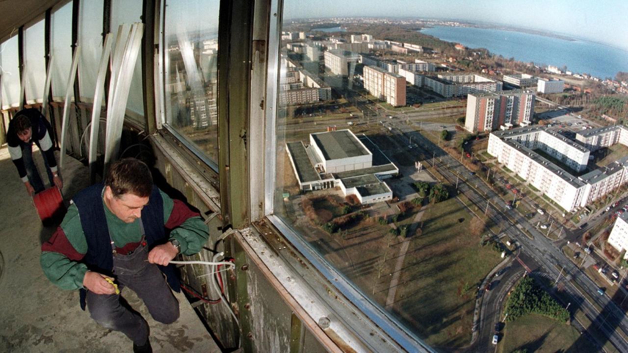 Techniker verlegten 1997 im auch damals geschlossenen Turmcafe des Schweriner Fernsehturms Kabel. Durch die Fenster sieht man Plattenbautender Stadt. Techniker verlegten 1997 im auch damals geschlossenen Turmcafe des Schweriner Fernsehturms Kabel. Durch die Fenster sieht man Plattenbautender Stadt.