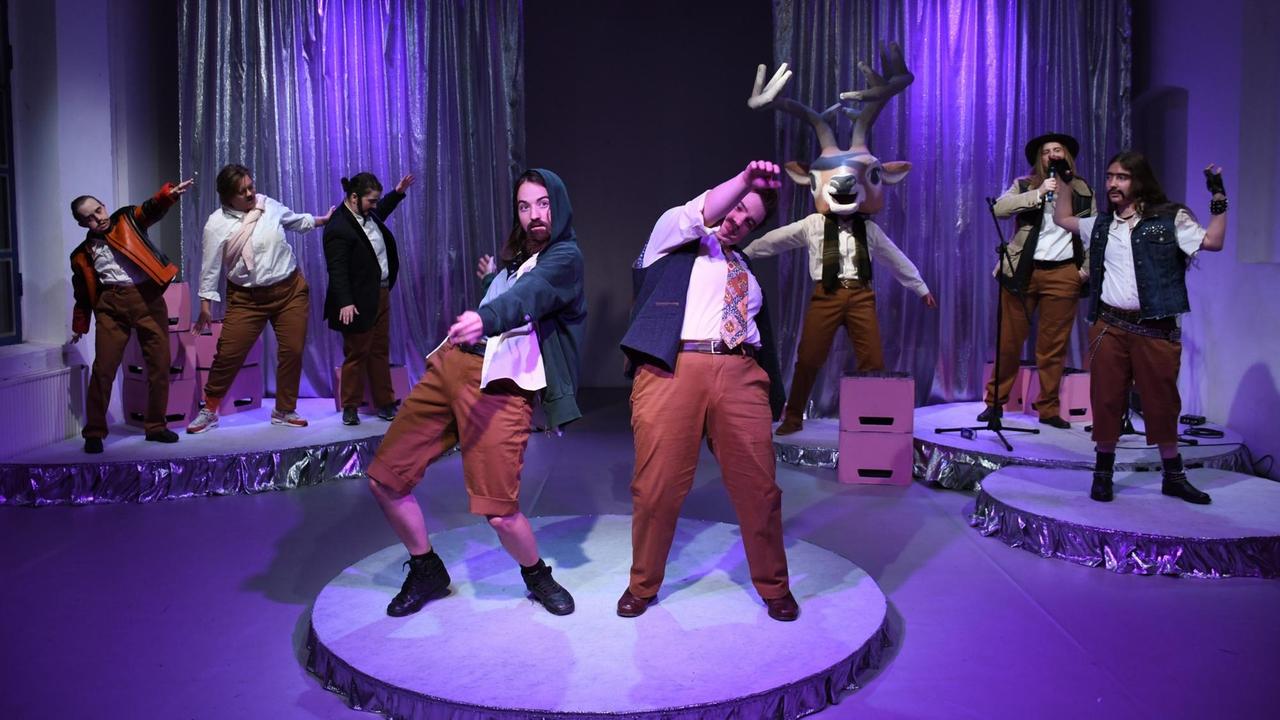 In Männerkostümen parodieren die Performerinnen "typisch männliches" Verhalten. Ein Platzhirsch ist auch dabei. In Männerkostümen parodieren die Performerinnen "typisch männliches" Verhalten. Ein Platzhirsch ist auch dabei.
