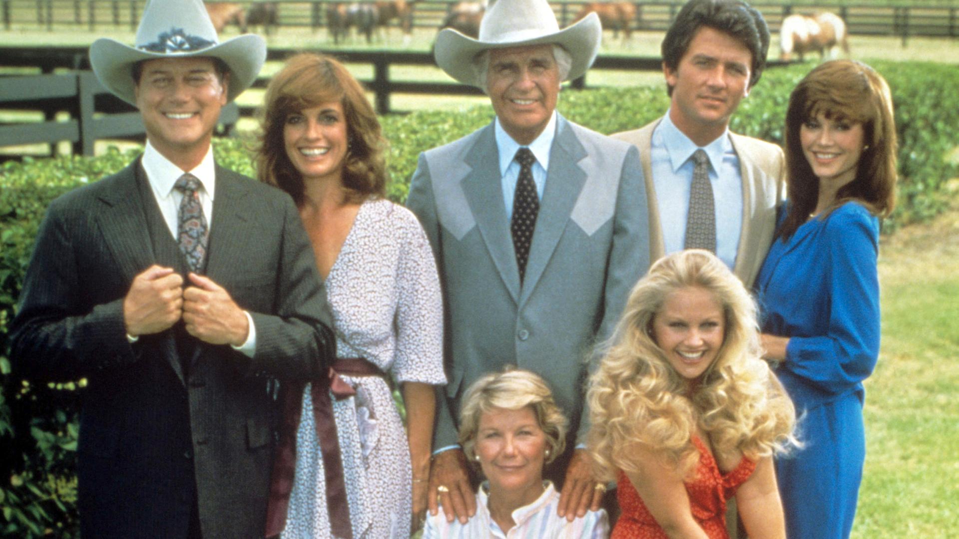 Die Hauptdarsteller der US-Fernsehserie "Dallas" (v.l. hinten): Larry Hagmann als Fiesling J. R. Ewing, Linda Gray als dessen Frau Sue-Ellen, Jim Davis als Vater Jock Ewing, Patrick Duffy als J. R.'s "guter" Bruder Bobby Ewing und Victoria Principal als dessen Frau Pamela Ewing. Vorne im Stuhl sitzend Barbara Bel Geddes als Jock's Ehefrau Miss Ellie Ewing und daneben Charlene Tilton als Enkelin Lucy (undatierte Aufnahme) Die Hauptdarsteller der US-Fernsehserie "Dallas" (v.l. hinten): Larry Hagmann als Fiesling J. R. Ewing, Linda Gray als dessen Frau Sue-Ellen, Jim Davis als Vater Jock Ewing, Patrick Duffy als J. R.'s "guter" Bruder Bobby Ewing und Victoria Principal als dessen Frau Pamela Ewing. Vorne im Stuhl sitzend Barbara Bel Geddes als Jock's Ehefrau Miss Ellie Ewing und daneben Charlene Tilton als Enkelin Lucy (undatierte Aufnahme)