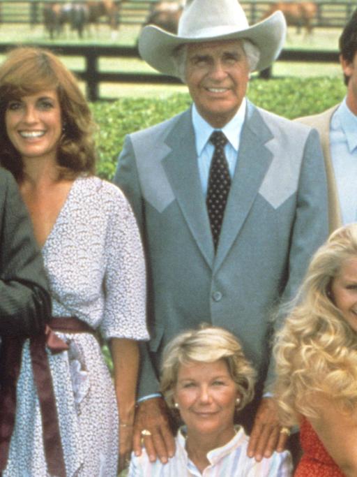 Die Hauptdarsteller der US-Fernsehserie "Dallas" (v.l. hinten): Larry Hagmann als Fiesling J. R. Ewing, Linda Gray als dessen Frau Sue-Ellen, Jim Davis als Vater Jock Ewing, Patrick Duffy als J. R.'s "guter" Bruder Bobby Ewing und Victoria Principal als dessen Frau Pamela Ewing. Vorne im Stuhl sitzend Barbara Bel Geddes als Jock's Ehefrau Miss Ellie Ewing und daneben Charlene Tilton als Enkelin Lucy (undatierte Aufnahme)