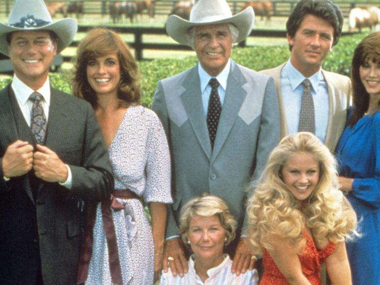 Die Hauptdarsteller der US-Fernsehserie "Dallas" (v.l. hinten): Larry Hagmann als Fiesling J. R. Ewing, Linda Gray als dessen Frau Sue-Ellen, Jim Davis als Vater Jock Ewing, Patrick Duffy als J. R.'s "guter" Bruder Bobby Ewing und Victoria Principal als dessen Frau Pamela Ewing. Vorne im Stuhl sitzend Barbara Bel Geddes als Jock's Ehefrau Miss Ellie Ewing und daneben Charlene Tilton als Enkelin Lucy (undatierte Aufnahme)