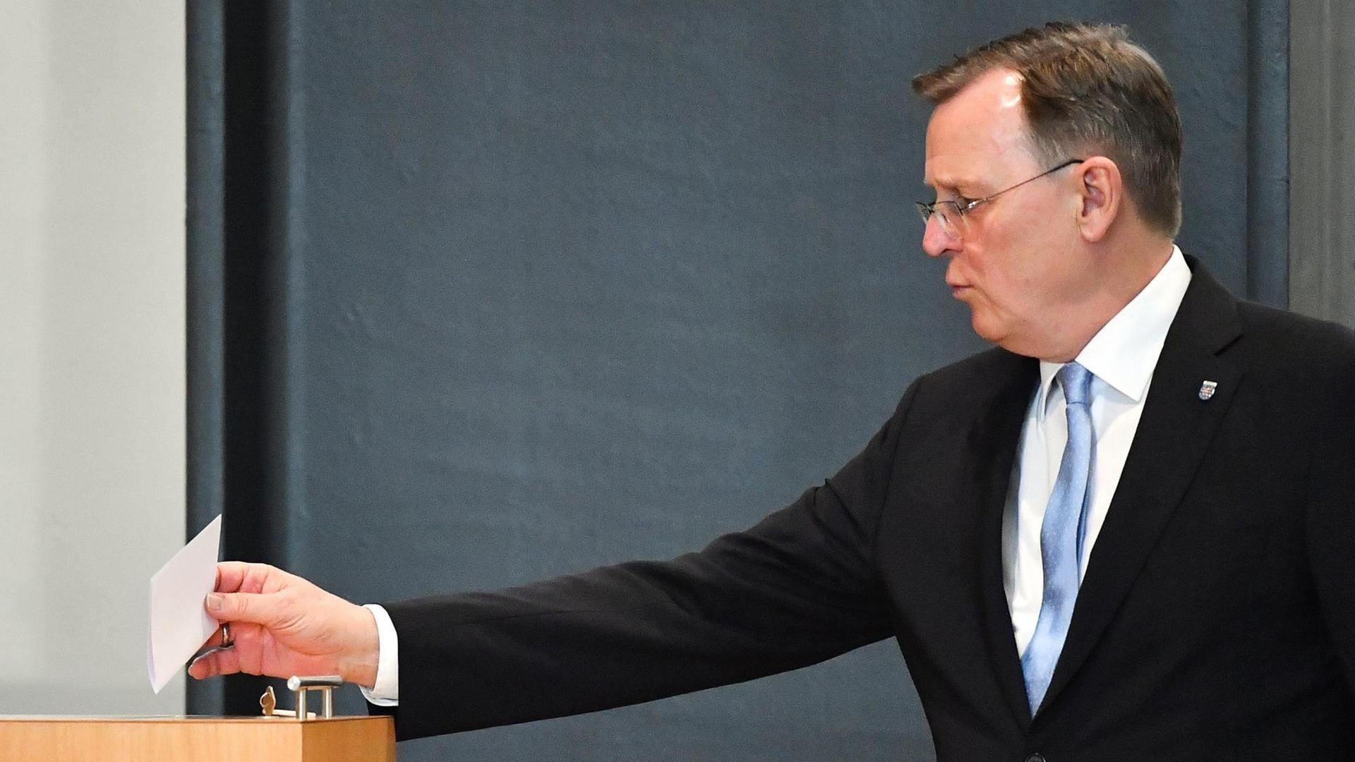 Der Politiker Bodo Ramelow wirft einen Stimmzettel in eine Urne. Er trägt einen dunklen Anzug. Der Politiker Bodo Ramelow wirft einen Stimmzettel in eine Urne. Er trägt einen dunklen Anzug.