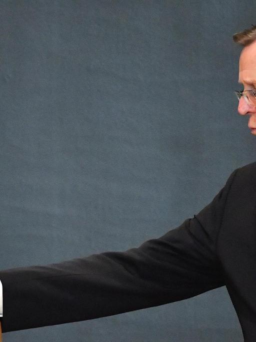 Der Politiker Bodo Ramelow wirft einen Stimmzettel in eine Urne. Er trägt einen dunklen Anzug.