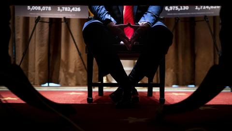 Unter dem Tisch verschränkt Donald J. Trump seine Beine und Hände.