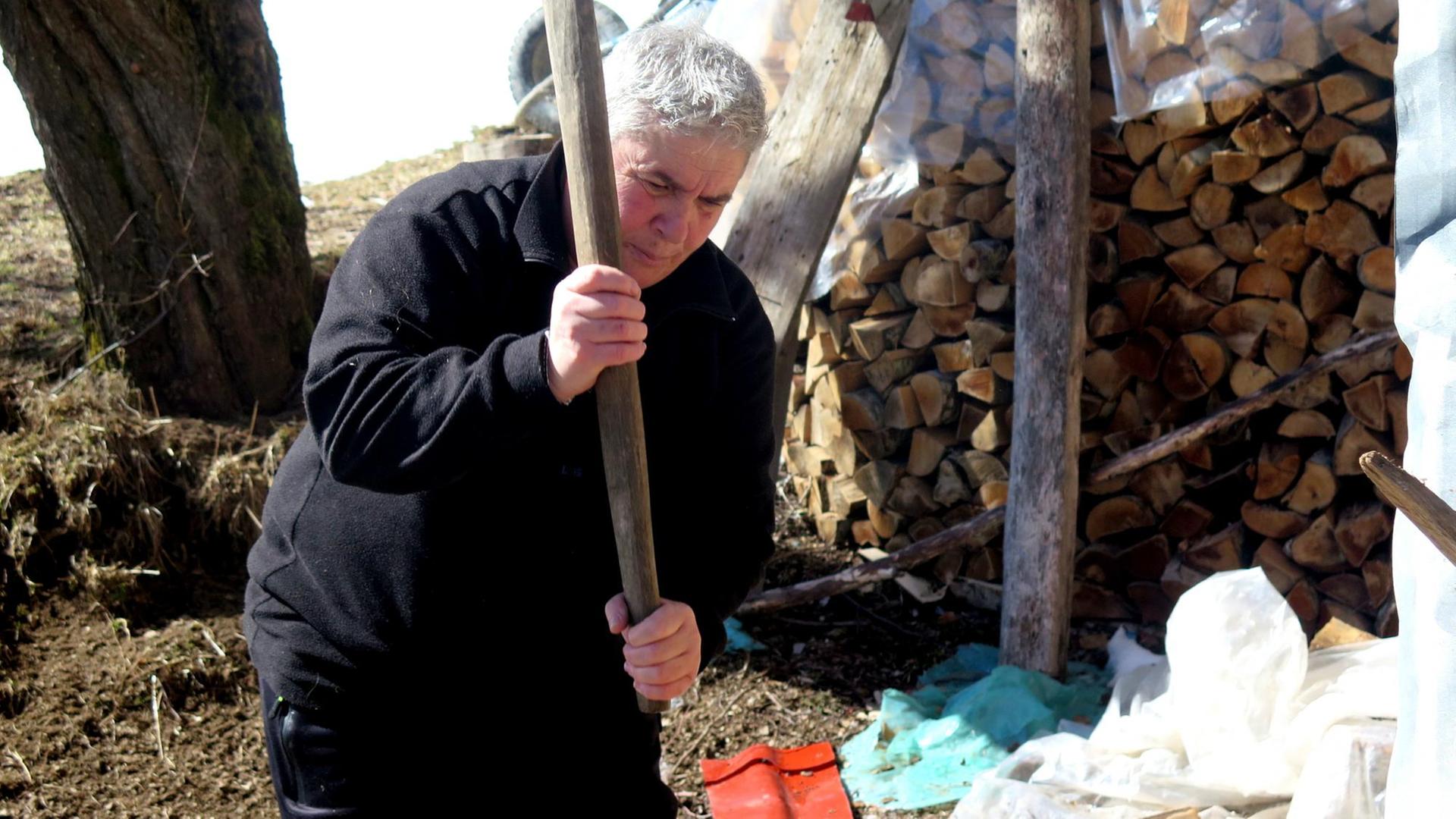 Eine der letzten "Schwurjungfrauen" Albaniens, Duni Grishaj, beim Holzhacken Eine der letzten "Schwurjungfrauen" Albaniens, Duni Grishaj, beim Holzhacken