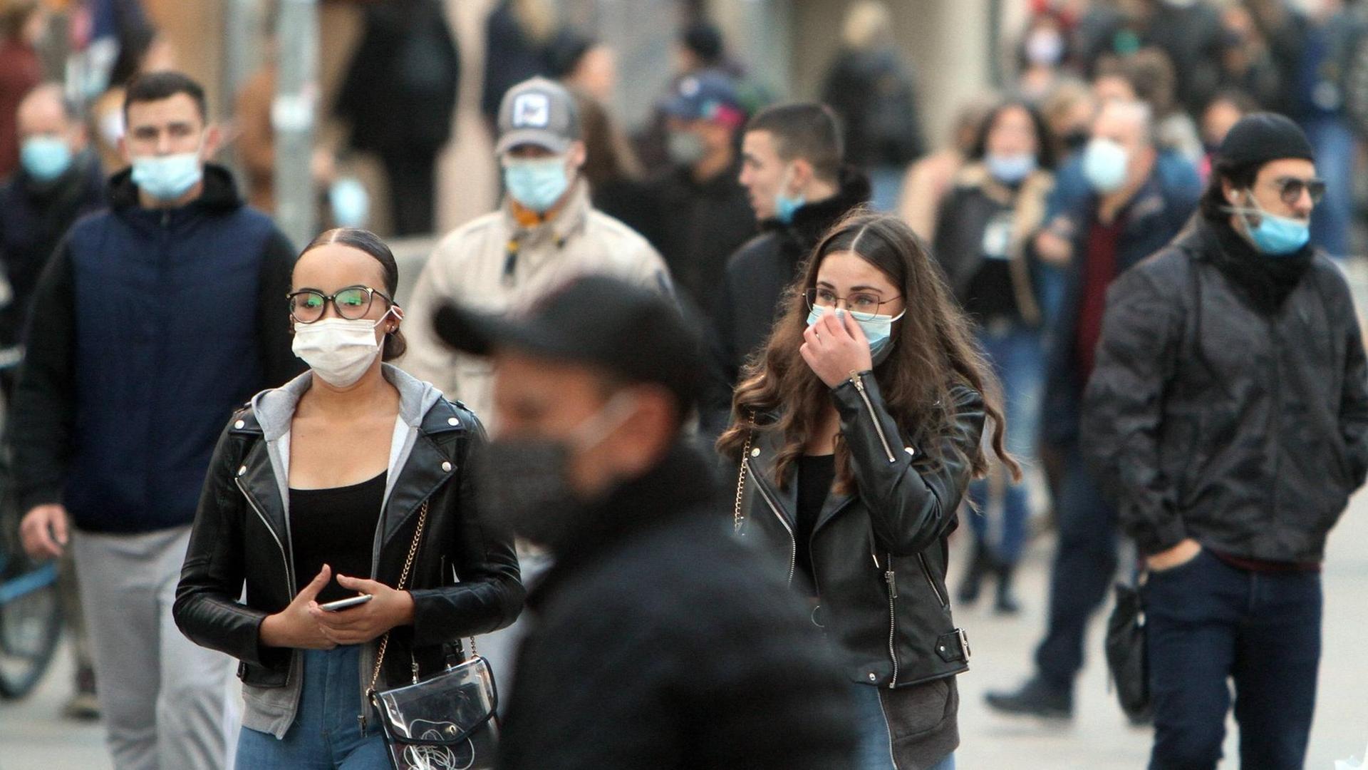 Das Foto zeigt Menschen in der Stadt, sie tragen Mund-Nasen-Schutz. Das Foto zeigt Menschen in der Stadt, sie tragen Mund-Nasen-Schutz.