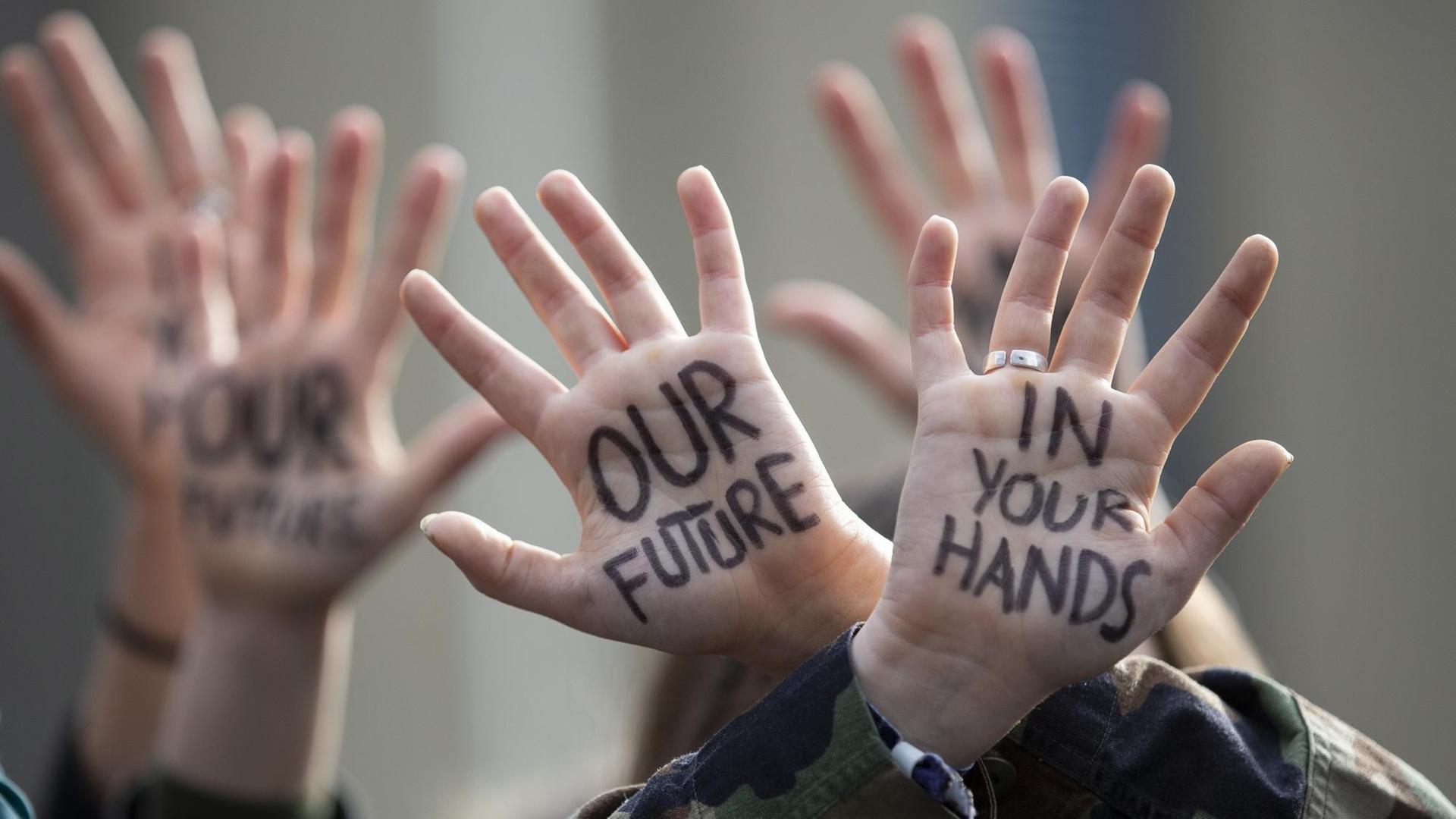 Protestmarsch von Jugendlichen in Brüssel, Belgien. Auf den hochgehaltenen Handflächen steht: "Our Future - in your Hands". Protestmarsch von Jugendlichen in Brüssel, Belgien. Auf den hochgehaltenen Handflächen steht: "Our Future - in your Hands".