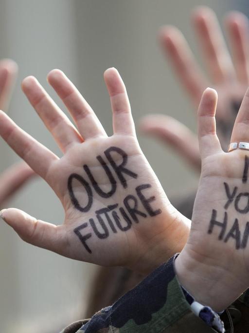 Protestmarsch von Jugendlichen in Brüssel, Belgien. Auf den hochgehaltenen Handflächen steht: "Our Future - in your Hands".