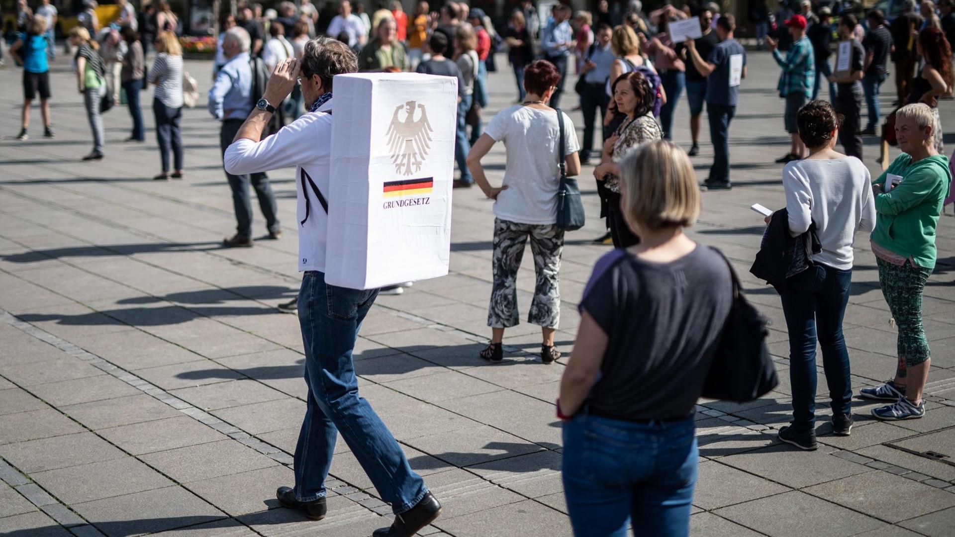 "Grundgesetz" steht auf einem Schild an dem Rücken eines Teilnehmers einer Demonstration gegen die Einschränkungen der Grundrechte in Zeiten der Coronakrise.