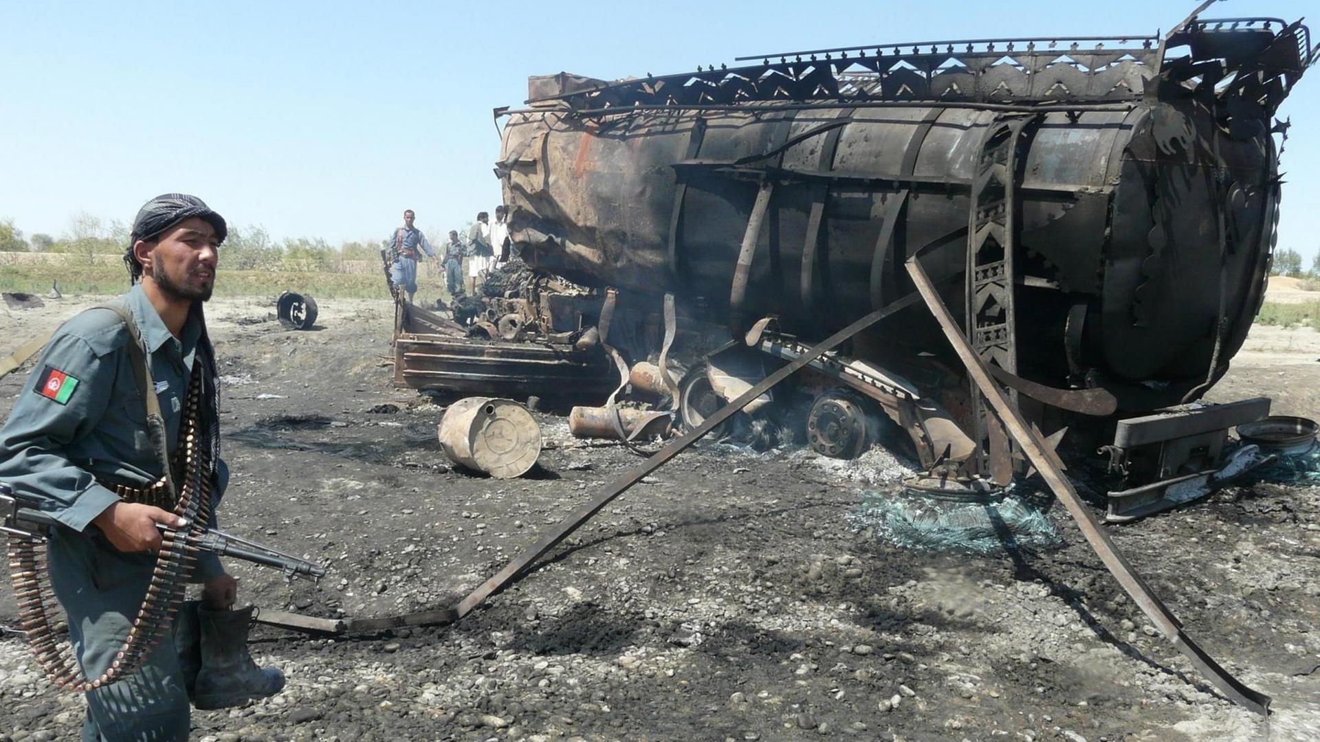 Die afghanische Polizei inspiziert die verbrannten Öltankwagen am Ort eines NATO-geführten Luftangriffs, der auf militante Taliban in Kundus, Nordafghanistan, abzielte, 04. September 2009. Mindestens 50 Menschen wurden getötet, als ein NATO-Luftangriff zwei von den Taliban gekaperte Öltankwagen in der nordafghanischen Provinz Kundus traf, als die Kämpfer Treibstoff an Zivilisten verteilten. Die afghanische Polizei inspiziert die verbrannten Öltankwagen am Ort eines NATO-geführten Luftangriffs, der auf militante Taliban in Kundus, Nordafghanistan, abzielte, 04. September 2009. Mindestens 50 Menschen wurden getötet, als ein NATO-Luftangriff zwei von den Taliban gekaperte Öltankwagen in der nordafghanischen Provinz Kundus traf, als die Kämpfer Treibstoff an Zivilisten verteilten.