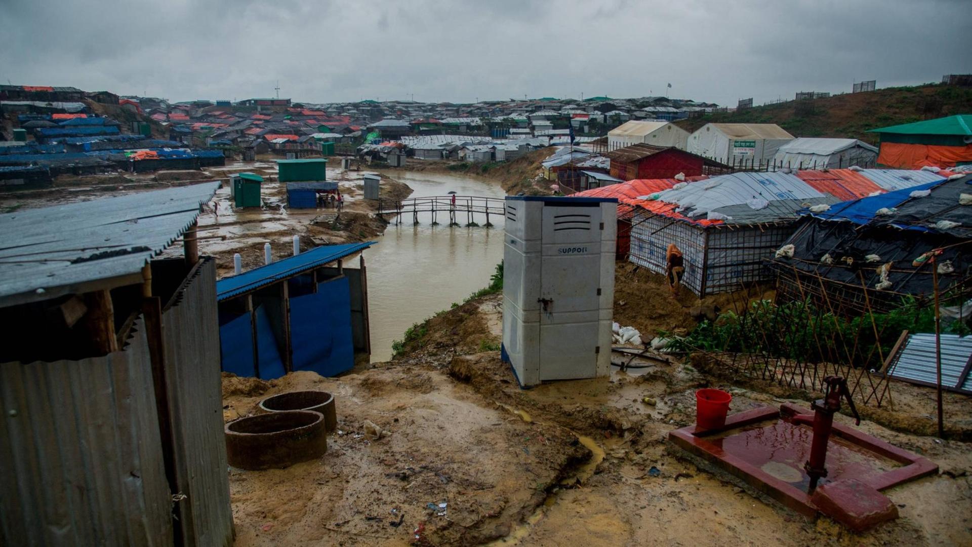 Blick über die aus Planen bestehenden Dächer der Hütten im Flüchtlingslager Kutupalong in Bangladesch im Juni 2018. Durch das Lager läuft ein Fluss, die Erde ist durchnässt und dreckig. Blick über die aus Planen bestehenden Dächer der Hütten im Flüchtlingslager Kutupalong in Bangladesch im Juni 2018. Durch das Lager läuft ein Fluss, die Erde ist durchnässt und dreckig.