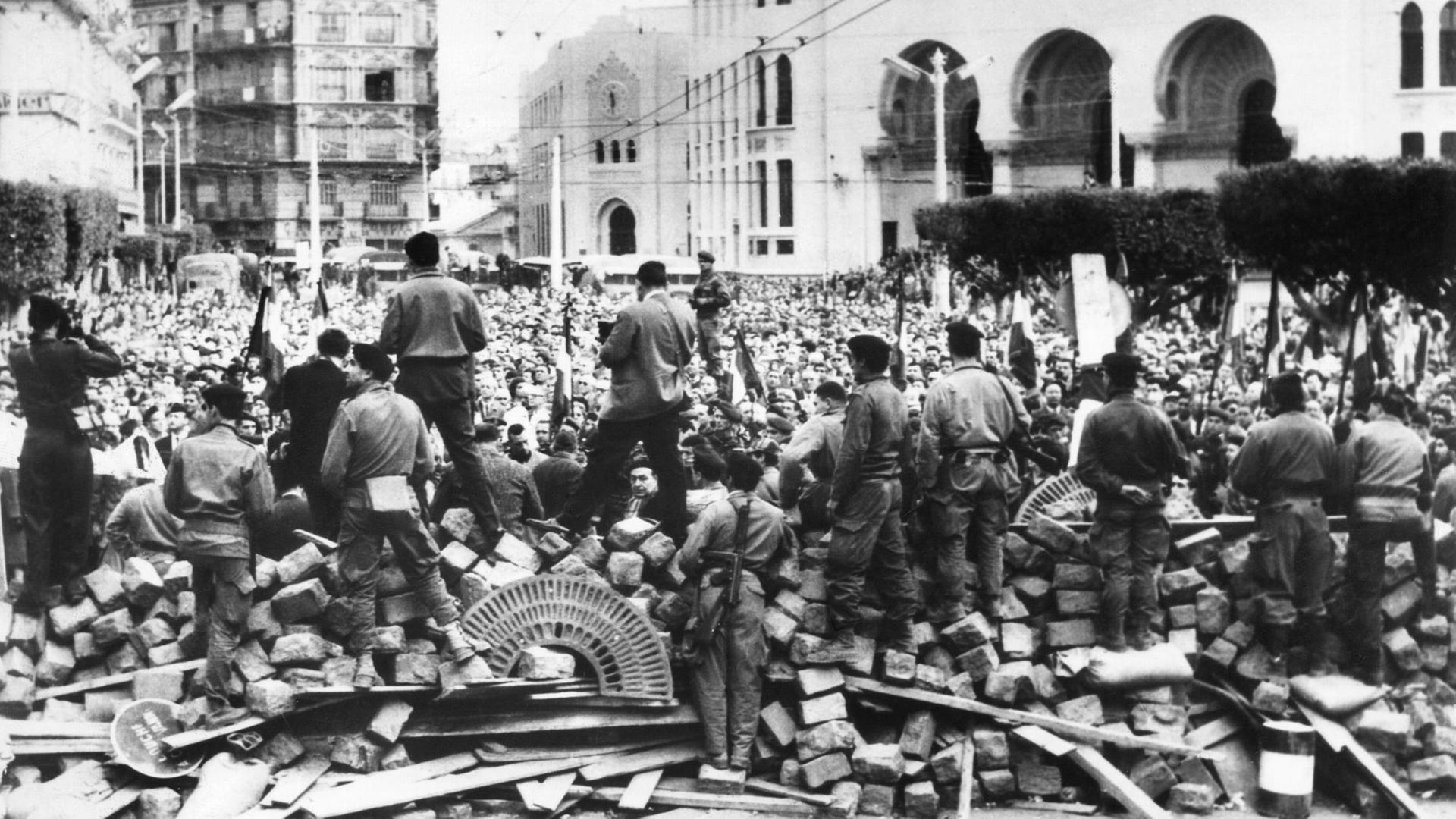 Im Hintergrund Algerien-Franzosen, Gegner der Unabhängigkeit Algeriens, während einer Demonstration Ende Januar 1960 in Algier. Im Vordergrund an den Barrikaden französische Fallschirmspringer. Im Hintergrund Algerien-Franzosen, Gegner der Unabhängigkeit Algeriens, während einer Demonstration Ende Januar 1960 in Algier. Im Vordergrund an den Barrikaden französische Fallschirmspringer.