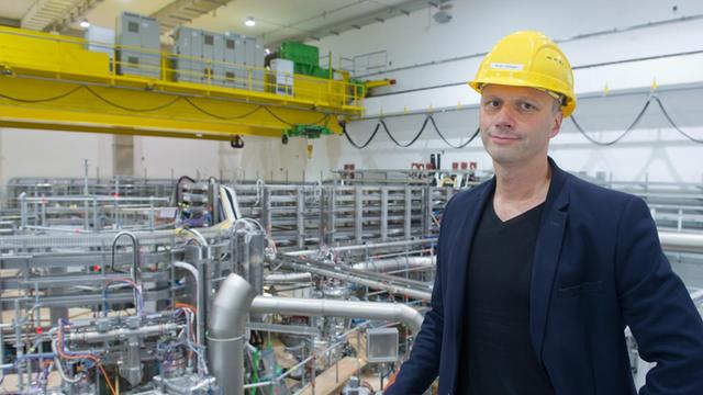 Der Direktor am Max-Planck-Institut für Plasmaphysik, Thomas Klinger, steht am 18.09.2015 in Greifswald (Mecklenburg-Vorpommern) vor dem 725 Tonnen schweren, ringförmigen Plasmagefäß für das Kernfusionsexperiment "Wendelstein 7-X".