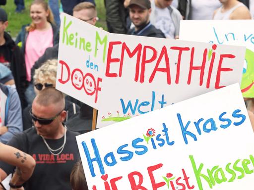 Teilnehmer des Zuges der Liebe - Rave für mehr Mitgefühl und Nächstenliebe mit Plakaten und Slogans: "Hass ist krass - LIEBE ist krasser - EMPATHIE - Keine Macht den DOOFEN!"