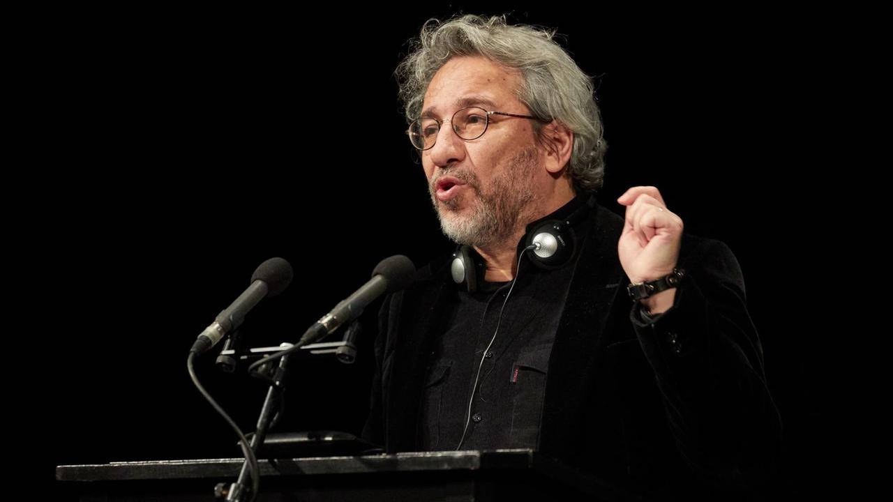 Der türkische Journalisten Can Dündar steht an einem Pult mit Mikrofonen und hält eine Rede. Der türkische Journalisten Can Dündar steht an einem Pult mit Mikrofonen und hält eine Rede.