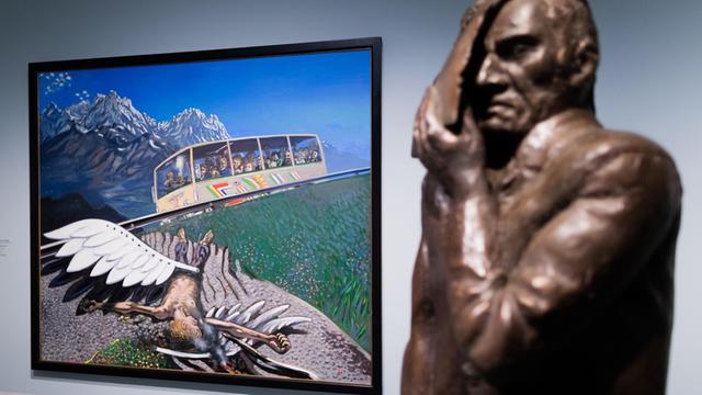 Das Bild "Seltsamer Zwischenfall" des Künstlers Wolfgang Mattheuer ist in der Ausstellung "Utopie und Untergang. Kunst in der DDR" hinter seiner Bronzefigur "Gesichtzeigen" zu sehen.