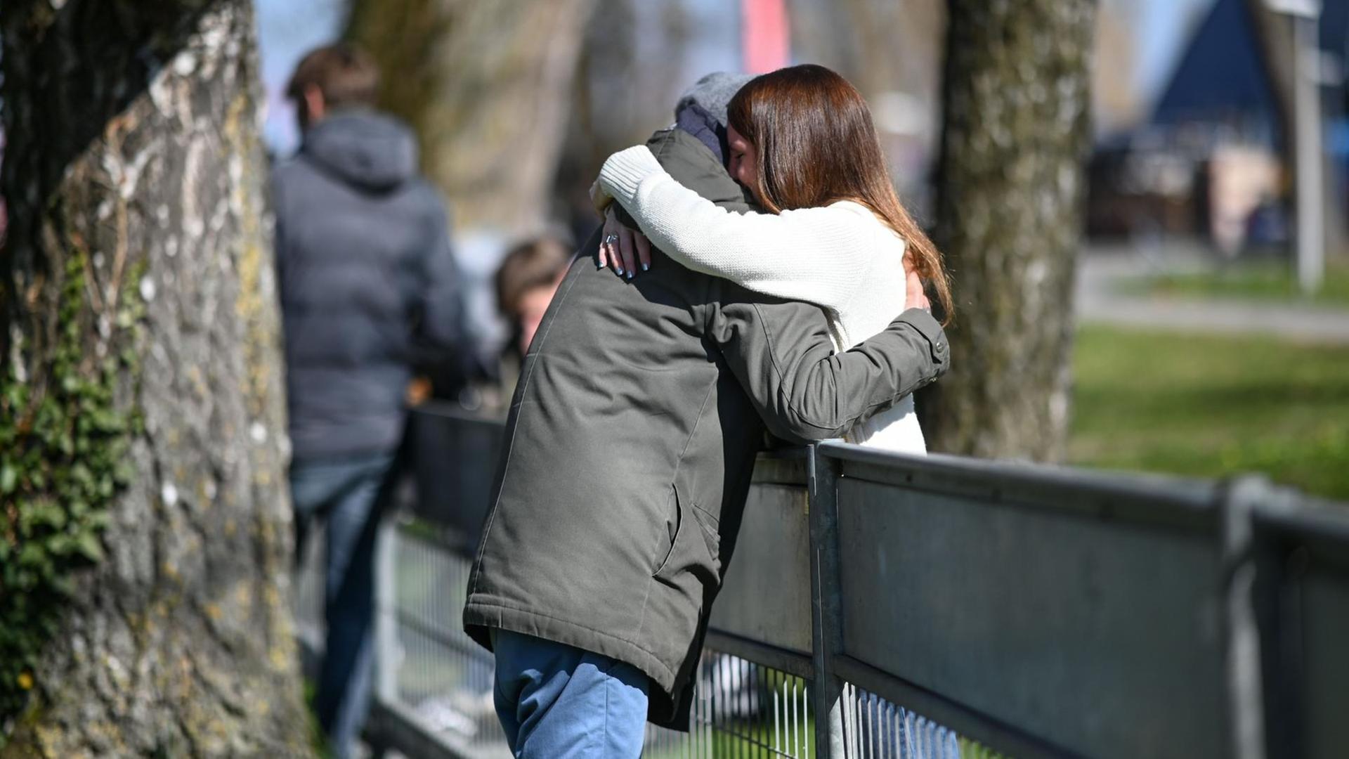 An der deutsch-schweizerischen Grenze nahe Konstanz und Kreuzlingen umarmt sich ein Pärchen, das wegen der Grenzschließung zwischen Deutschland und der Schweiz nicht beisammen sein kann. Das Paar kann sich nur an der Grenze treffen. An der deutsch-schweizerischen Grenze nahe Konstanz und Kreuzlingen umarmt sich ein Pärchen, das wegen der Grenzschließung zwischen Deutschland und der Schweiz nicht beisammen sein kann. Das Paar kann sich nur an der Grenze treffen.