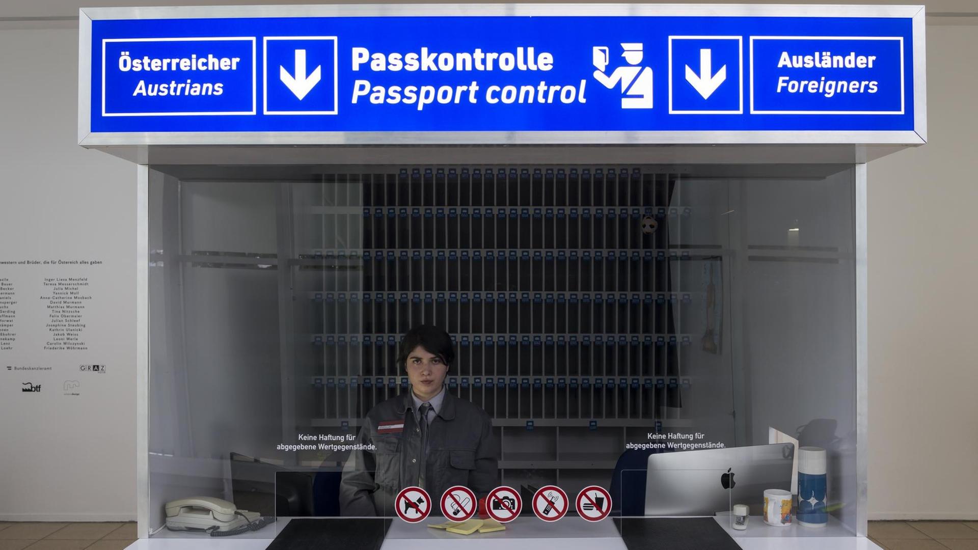 Eine Grenzbeamtin sitzt im Schalter zur Passkontrolle