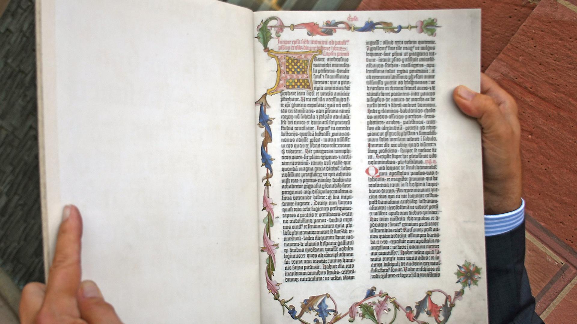 Der Mainzer Buchwissenschaftler Stephan Füssel hält ein Exemplar der neu erschienenen Reproduktion der Gutenberg-Bibel von 1454 in Händen