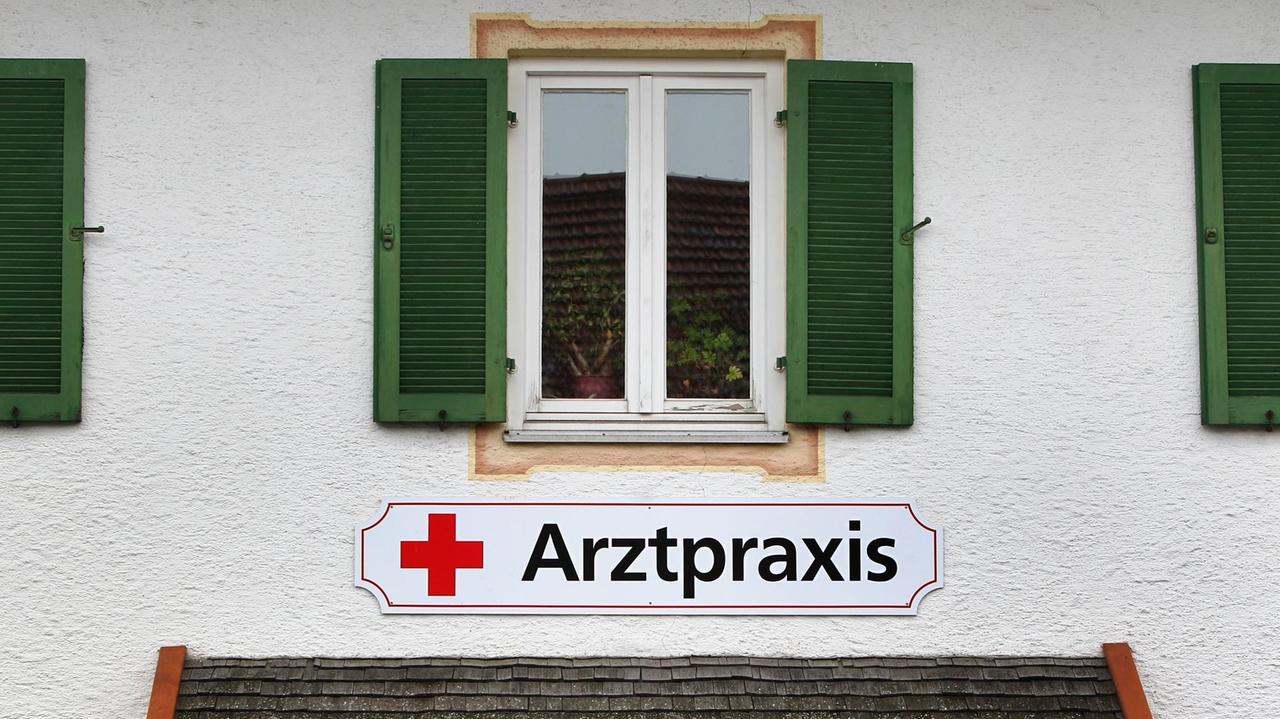 Ein Schild an einem älteren Haus weist in der kleinen Gemeinde Saulgrub (Bayern) auf eine Arztpraxis hin