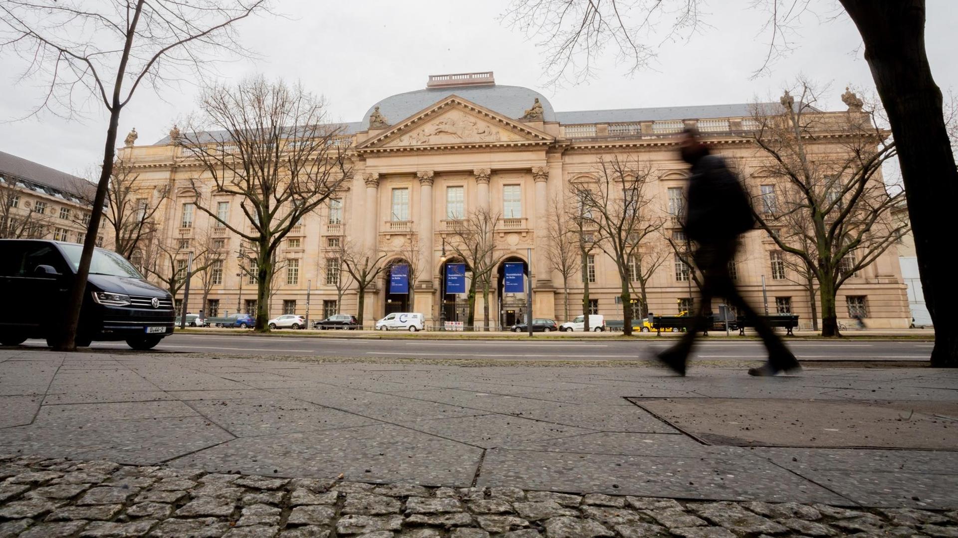 Ein Mensch geht an der Staats-Bibliothek Unter den Linden vorbei. Ein Mensch geht an der Staats-Bibliothek Unter den Linden vorbei.