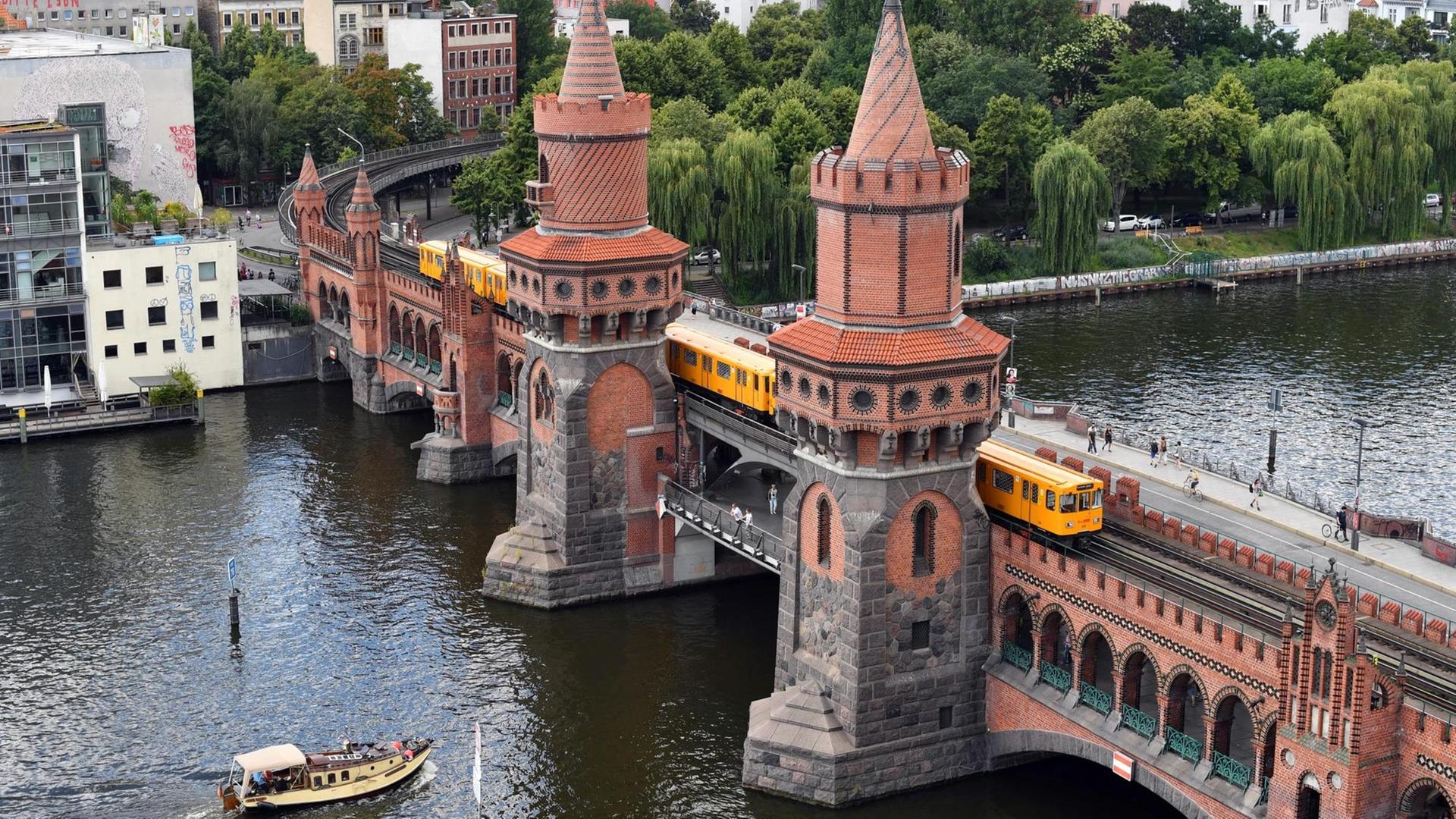 Das Foto zeigt den Blick auf die Oberbaumbrücke und einen U-Bahnzug über der Spree. Das Foto zeigt den Blick auf die Oberbaumbrücke und einen U-Bahnzug über der Spree.