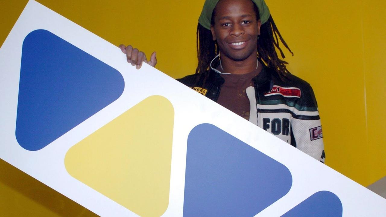 Der frühere VIVA-Moderator Mola Adebisi hält das Logo des Musiksenders in Händen.
