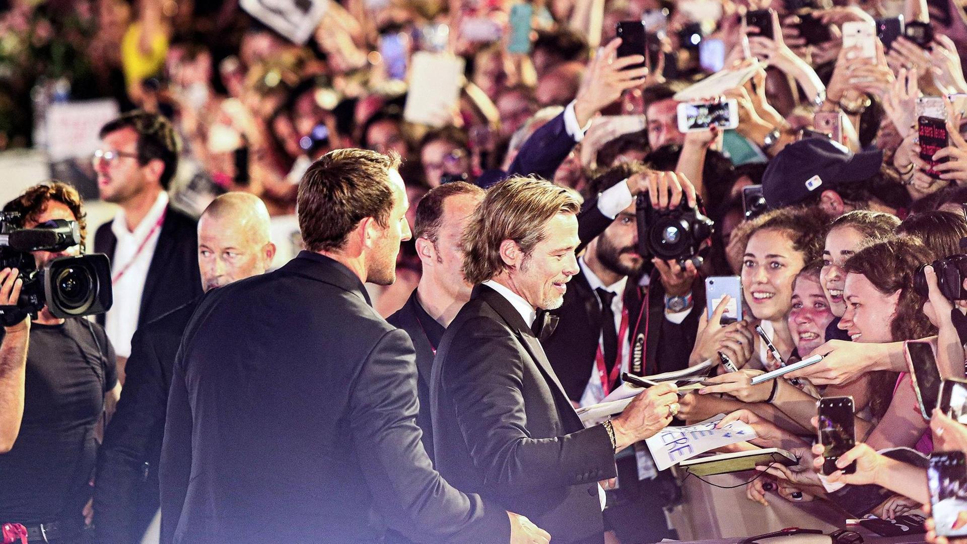 Brad Pitt gibt Fans Autogramme und ist von Fotografen umringt. Brad Pitt gibt Fans Autogramme und ist von Fotografen umringt.